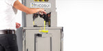 Person using a Frucosol Self-Service Juice machine to extract juice from fruits.