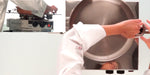 Person wearing a white chef's coat, holding a large pot over the Frucosol BC100 Cooking Machine.