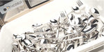 Set of silver cutlery including forks, knives, and spoons in the white cutlery tray with 'frucosol' branding behind.