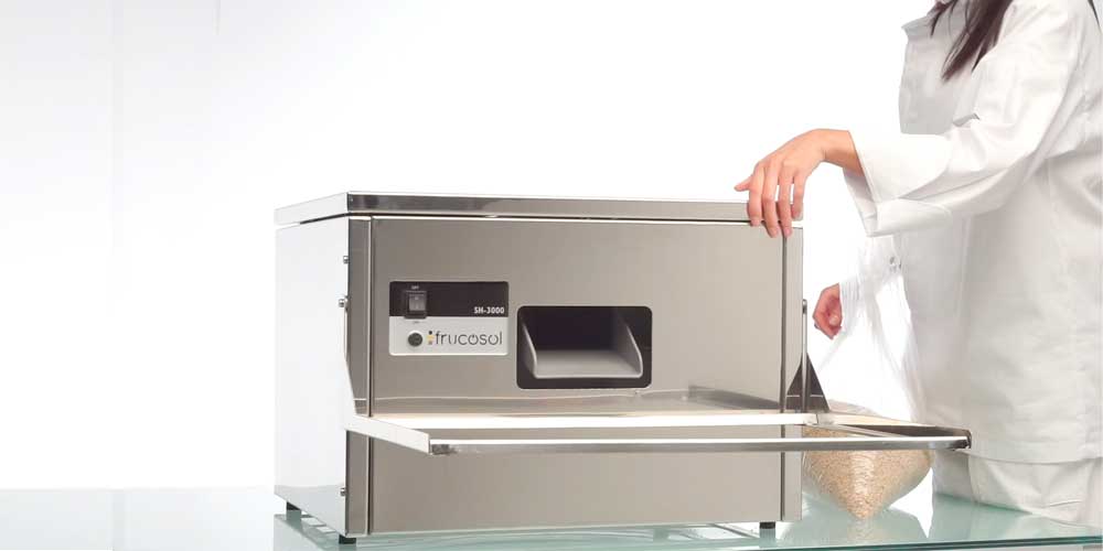 Frucosol SH3000 Cutlery Polisher, person taking the lid off of the unit to add cutlery polishing grain to the appliance.